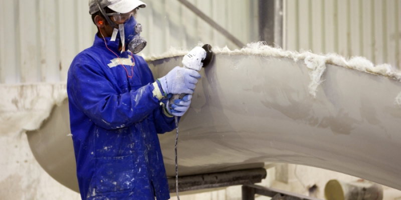 Fiberglass product being carefully handled during composite manufacturing process.